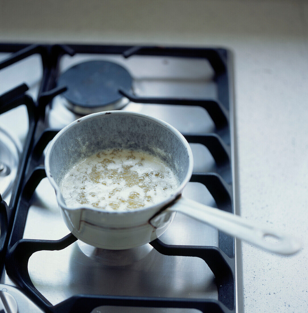 Saucepan of boiling butter on a gas hob