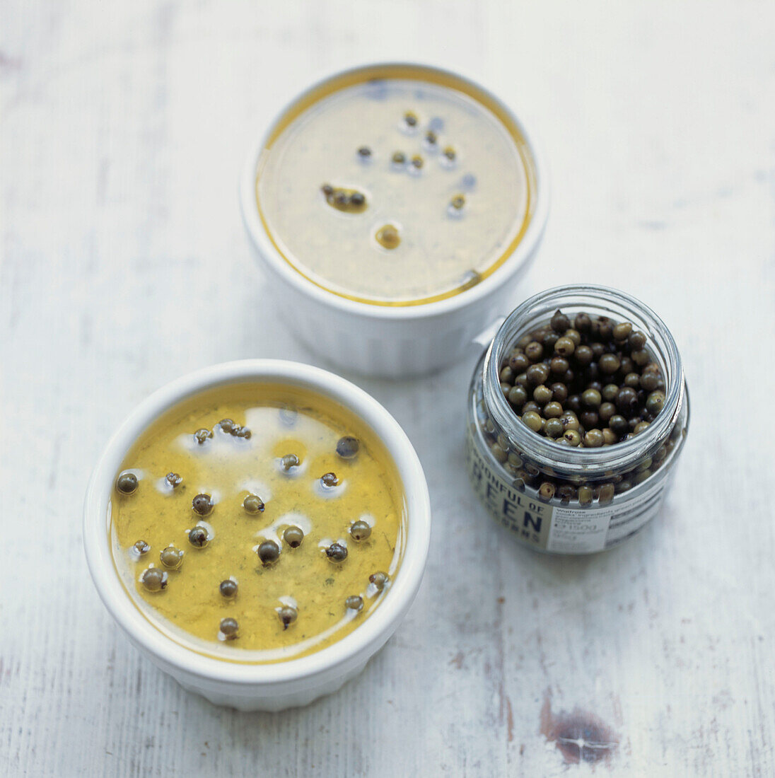 Pate prepared in ramekins with green peppercorn garnish