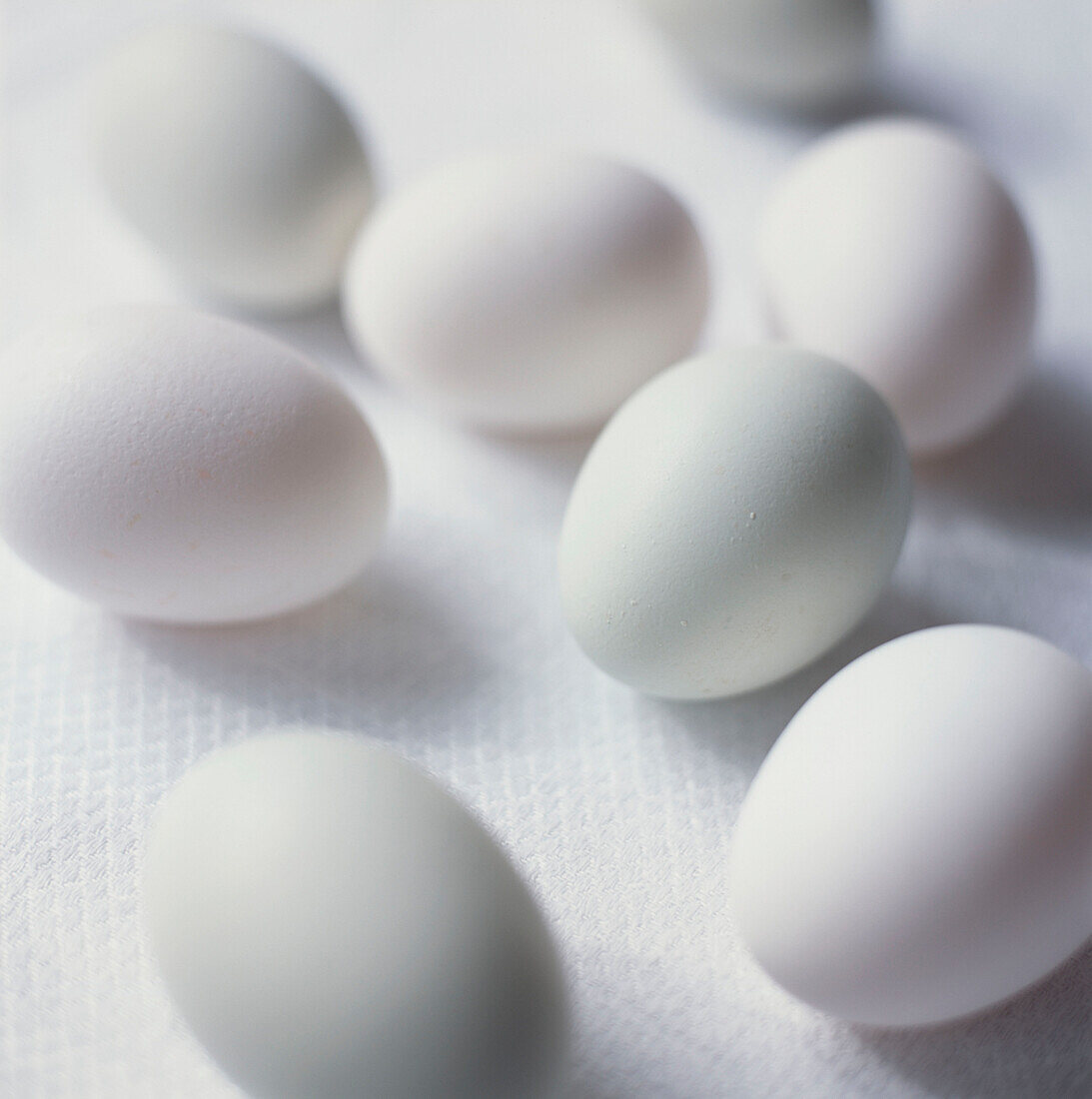 Group of chicken's eggs on a white linen background