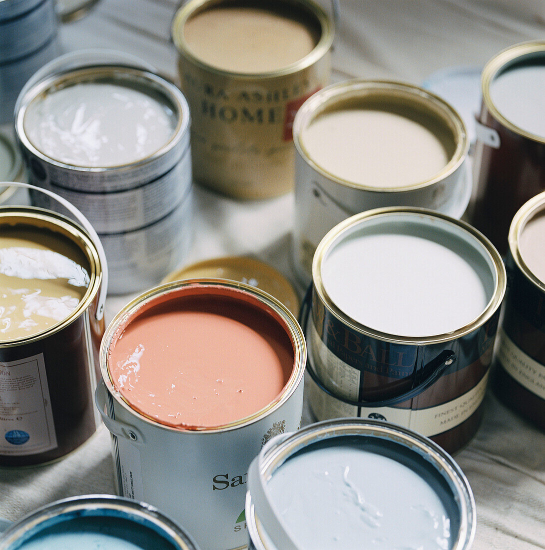 Lots of paint pots with the lids off displaying colours