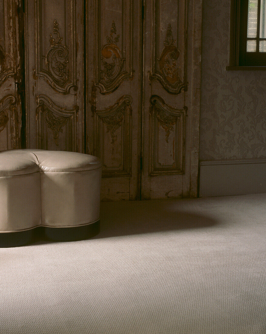 Neutral living room with ornate vintage panelled wall and carpet