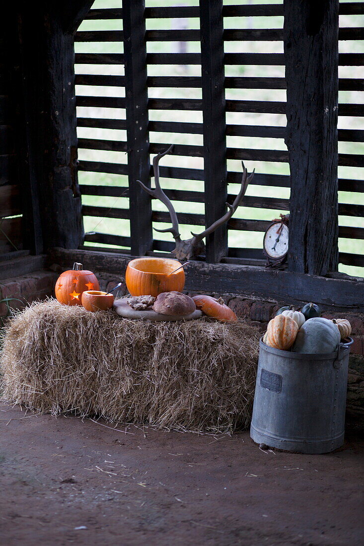 Pumpkins and hay bales in rustic barn interior, United Kingdom