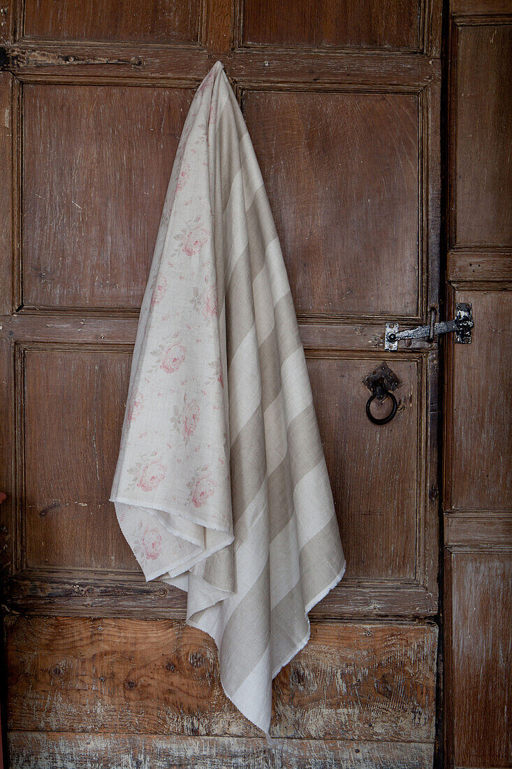 Fabric hanging on panelled wooden door, UK