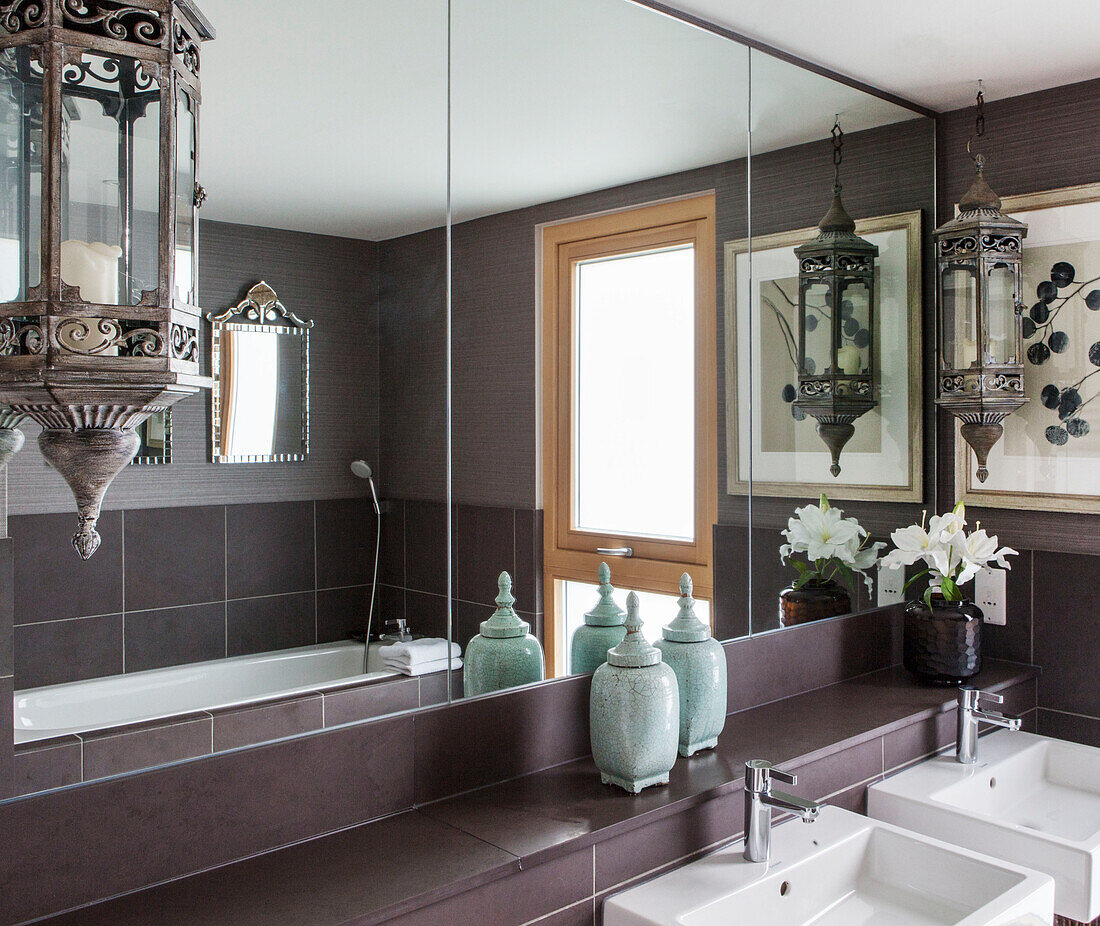 Vintage lanterns above double washbasins in bathroom of Lakes home, England, UK