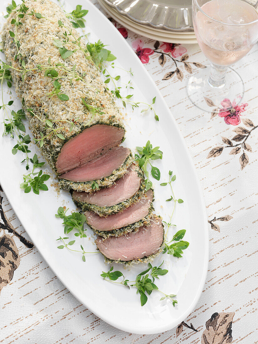 Sliced beef on serving dish with glass of rose wine Derwent Water, Cumbria, England UK