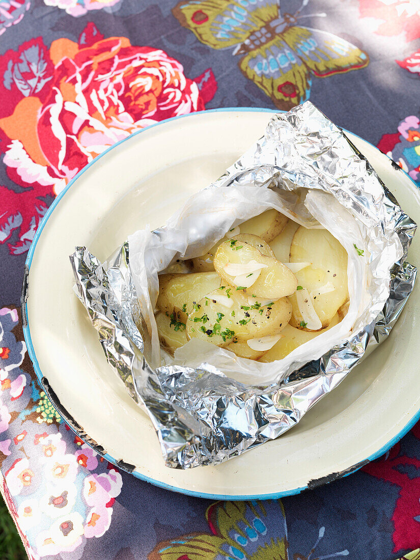 Foil baked new potatoes on plate England UK