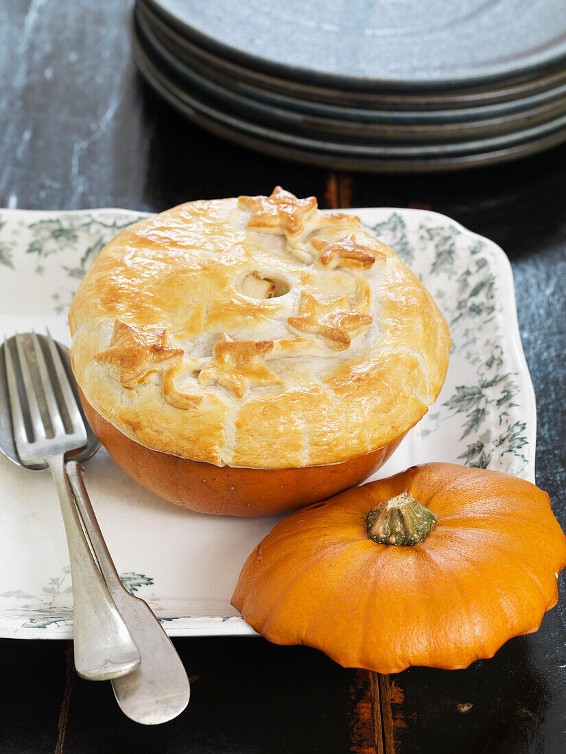 Pumpkin pie on serving dish with plates and cutlery Brighton, East Sussex UK