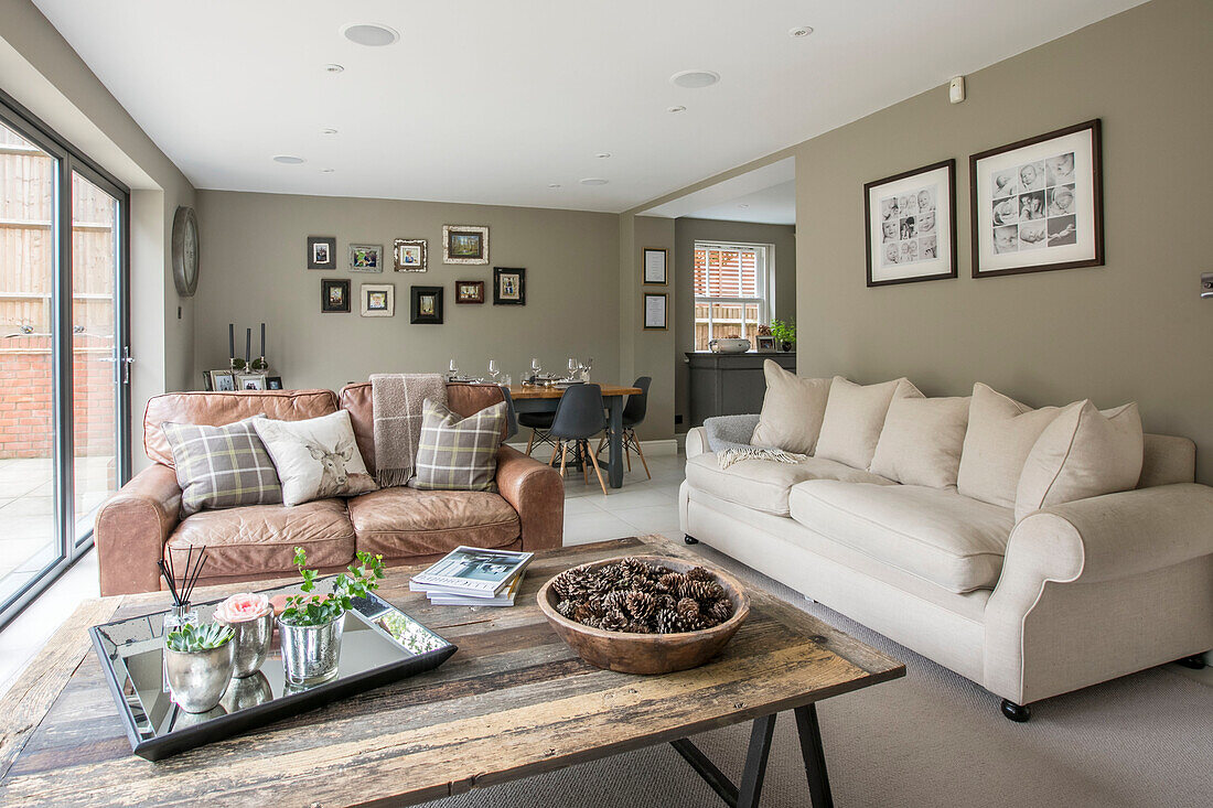 Pinecones on table with cream and leather sofas in open plan Guildford townhouse Surrey UK