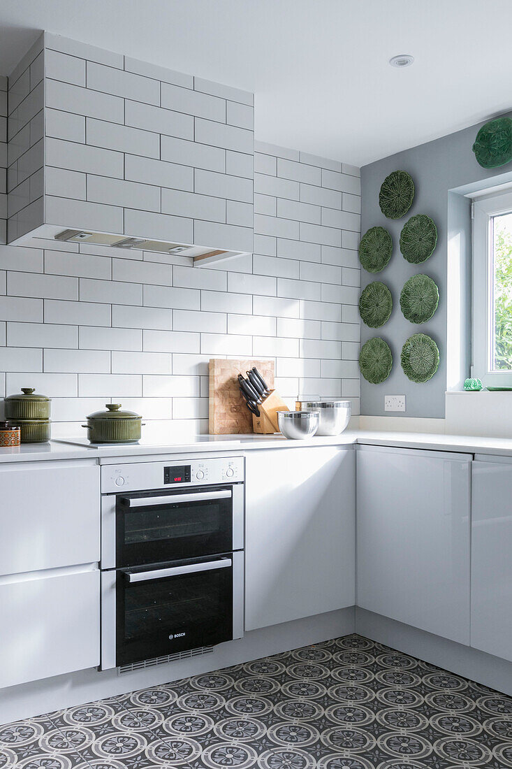 Decorative plates and oven with knifeblock in tiled Farnham kitchen Surrey UK