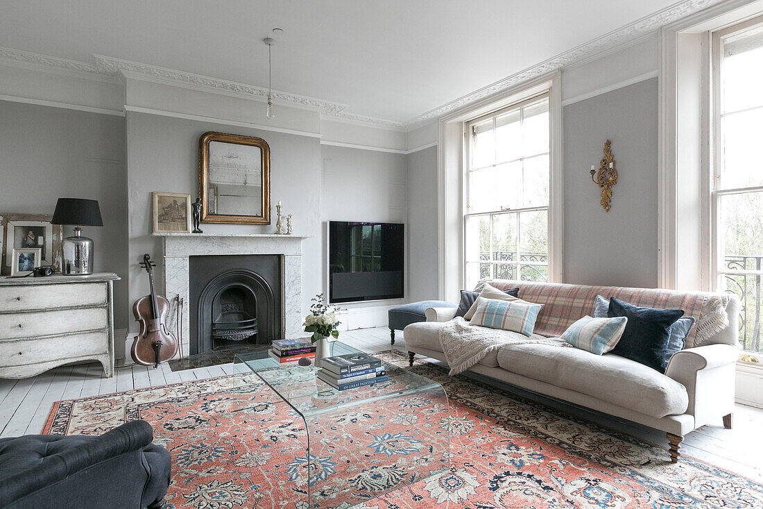 Perspex coffee table with sofa and rug with cello at fireplace in Winchester home UK