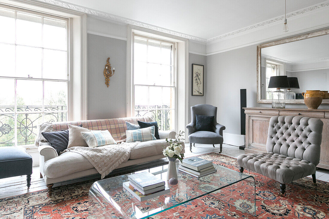 White sofa with checked cushions and grey armchair at window in Winchester home UK