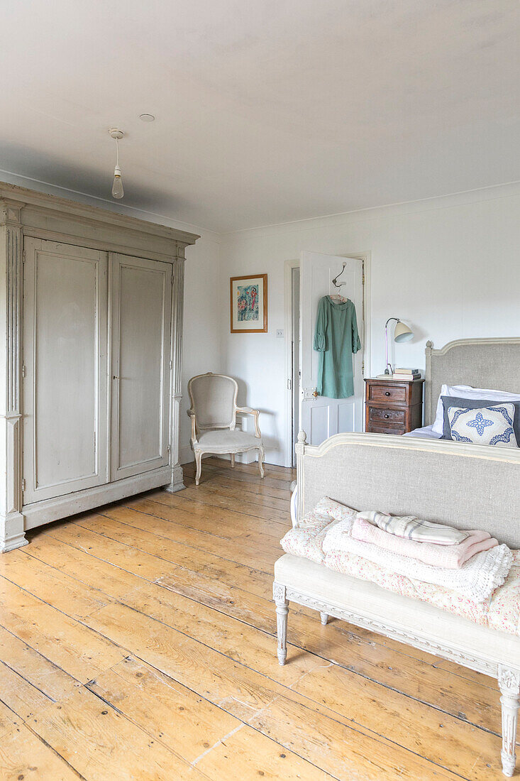 Large wardrobe and double bed with wooden floorboards in Winchester home UK