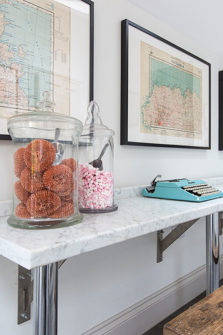 Scourers and sweets in glass storage jars with vintage typewriter and framed maps in Reading home Berkshire England UK