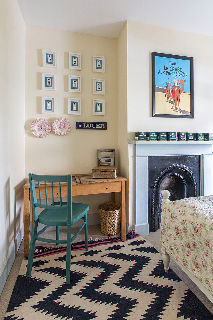 Schreibtisch und Stuhl mit gemustertem Teppich vor dem Kamin im Schlafzimmer eines Hauses in Reading, Berkshire, England UK