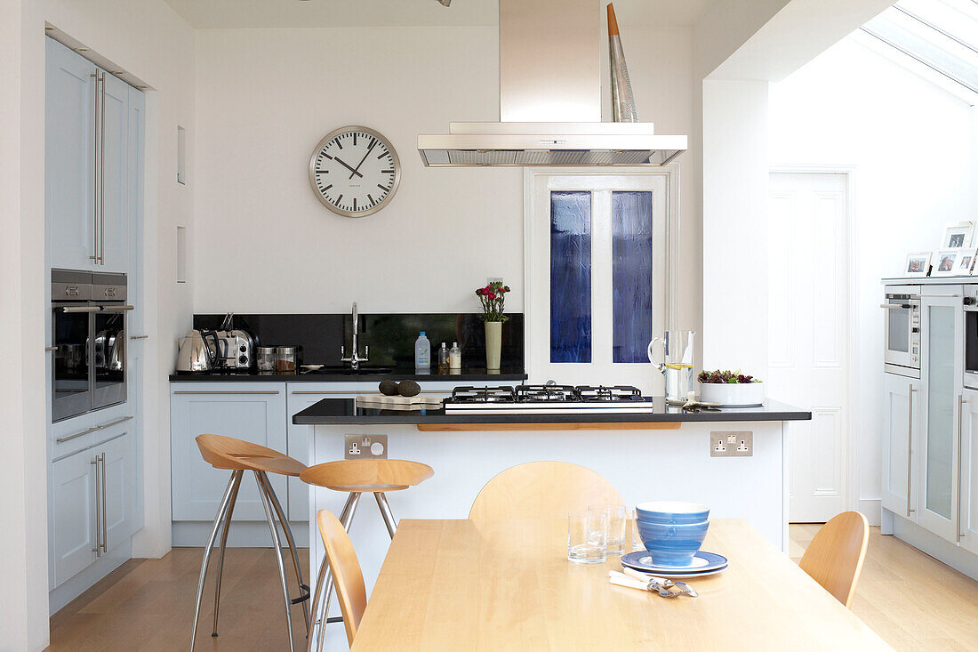 Light wood kitchen table with pale blue painted units