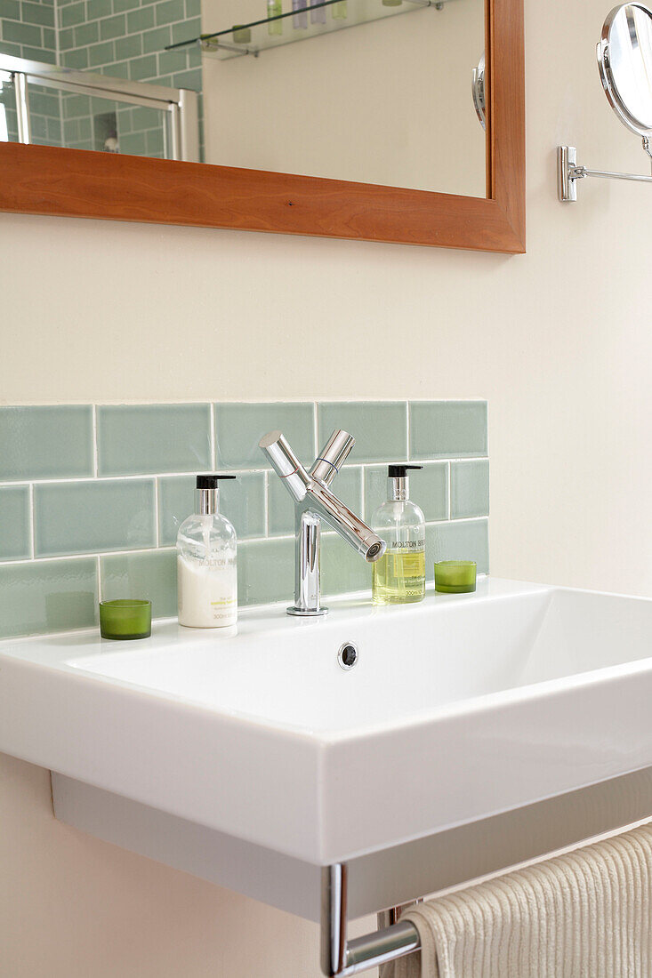 Green tiled splashback above sink in London home