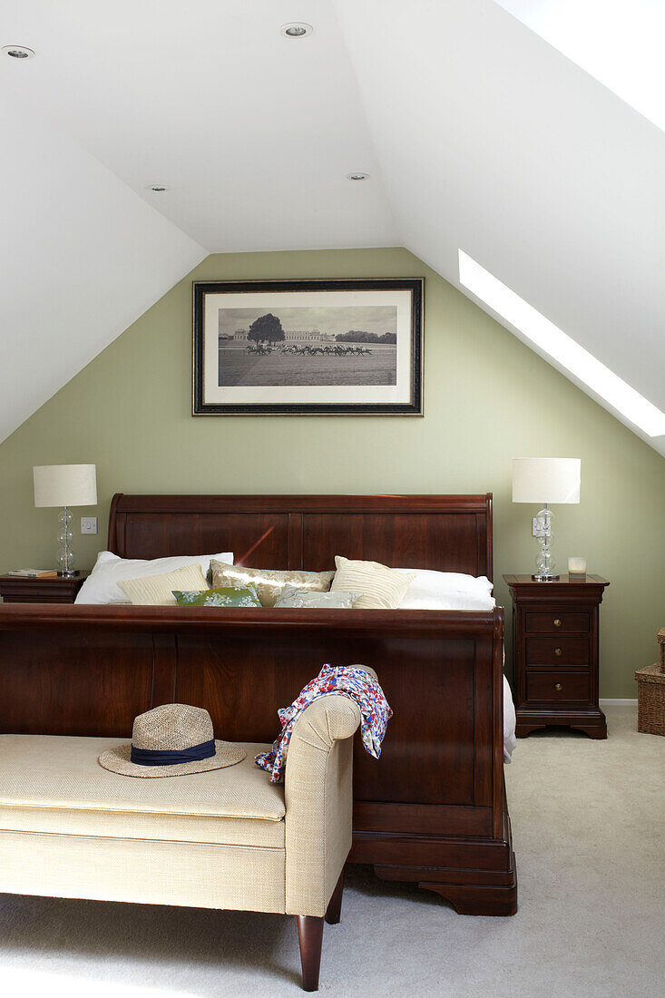 Antique wooden bed in attic conversion of Bembridge beach house, Isle of Wight, England, UK