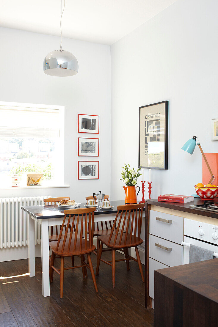 Wooden chairs at sunlit kitchen table in Isle of Wight home UK