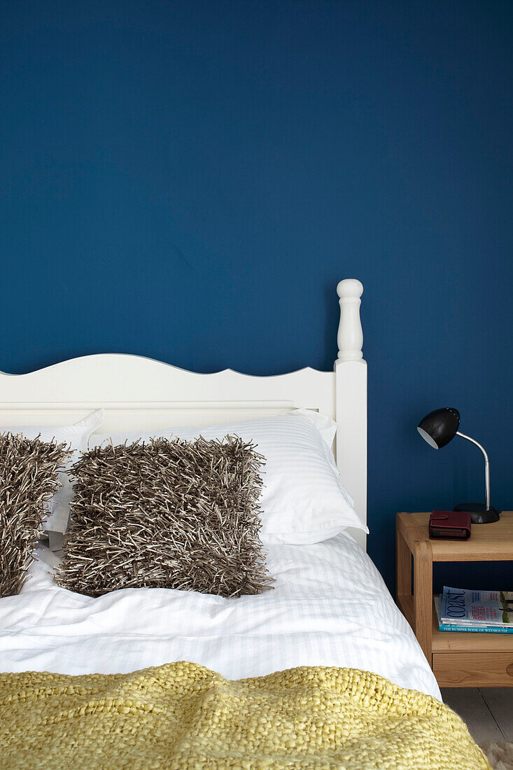 Mustard blanket and blue feature wall in contemporary Weymouth bedroom, Dorset, UK