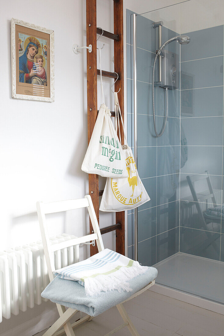 Kordelzugtaschen und gefaltete Handtücher mit Leiter im Badezimmer in Ryde, Isle of Wight, UK