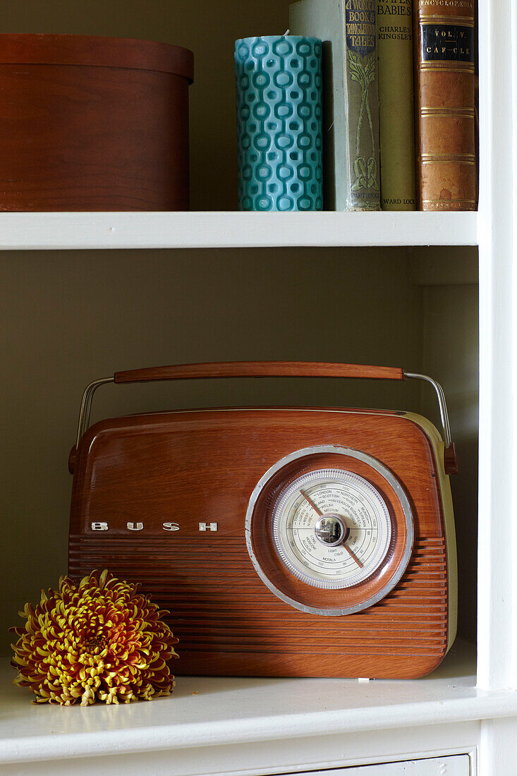 Radio und Ornament mit Büchern auf einem Regal in einem Haus in East Cowes, Isle of Wight, UK