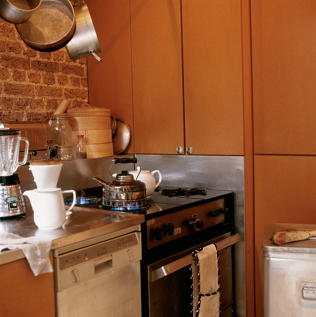 Stove with kettle being heated in small kitchen