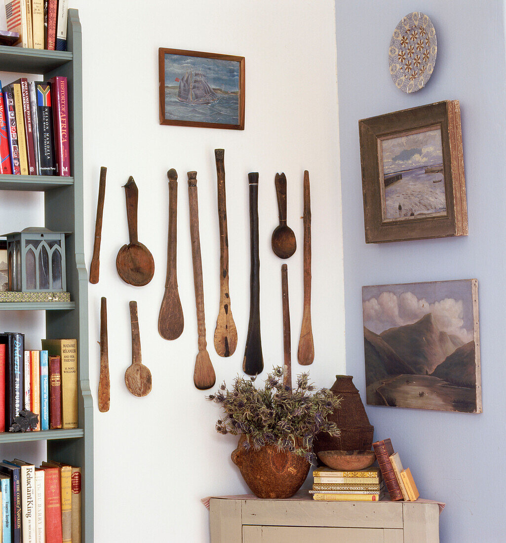 Room corner with hand carved African wooden spoon collection and bookcase