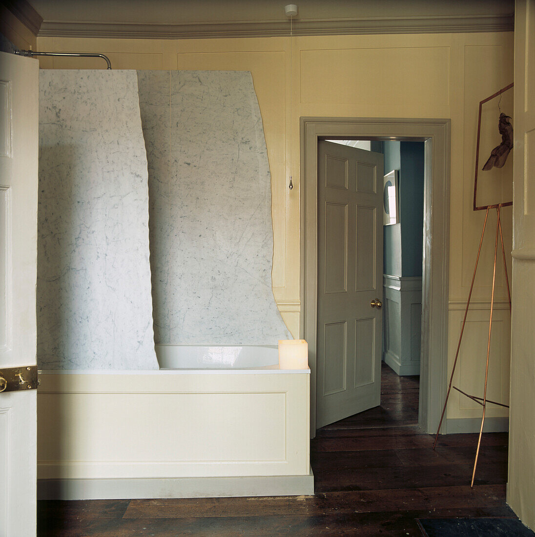 Carrara marble shower screen over fitted bath in wood panelled bathroom