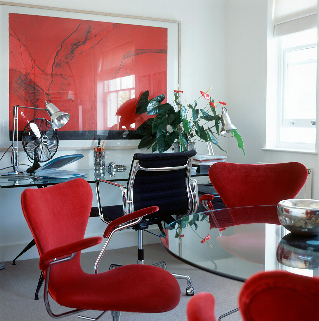 Weiß-rot-schwarzes Designer-Heimbüro mit Glastischen und stoffbezogenen Designerstühlen