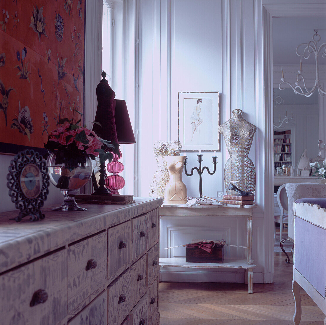 Elegant sitting room with collectibles on display on side table and chest of drawers covered with paper decoupage