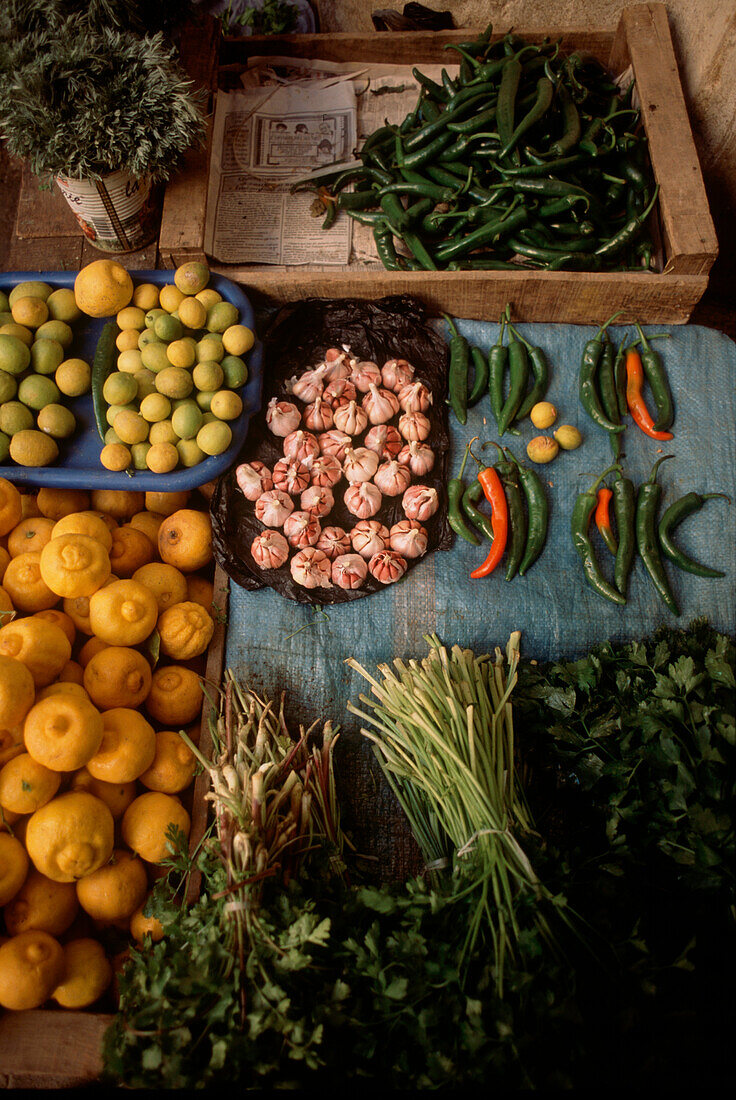 Draufsicht auf frisches Obst und Gemüse mit Knoblauch an einem Marktstand in der Medina von Fez, Marokko