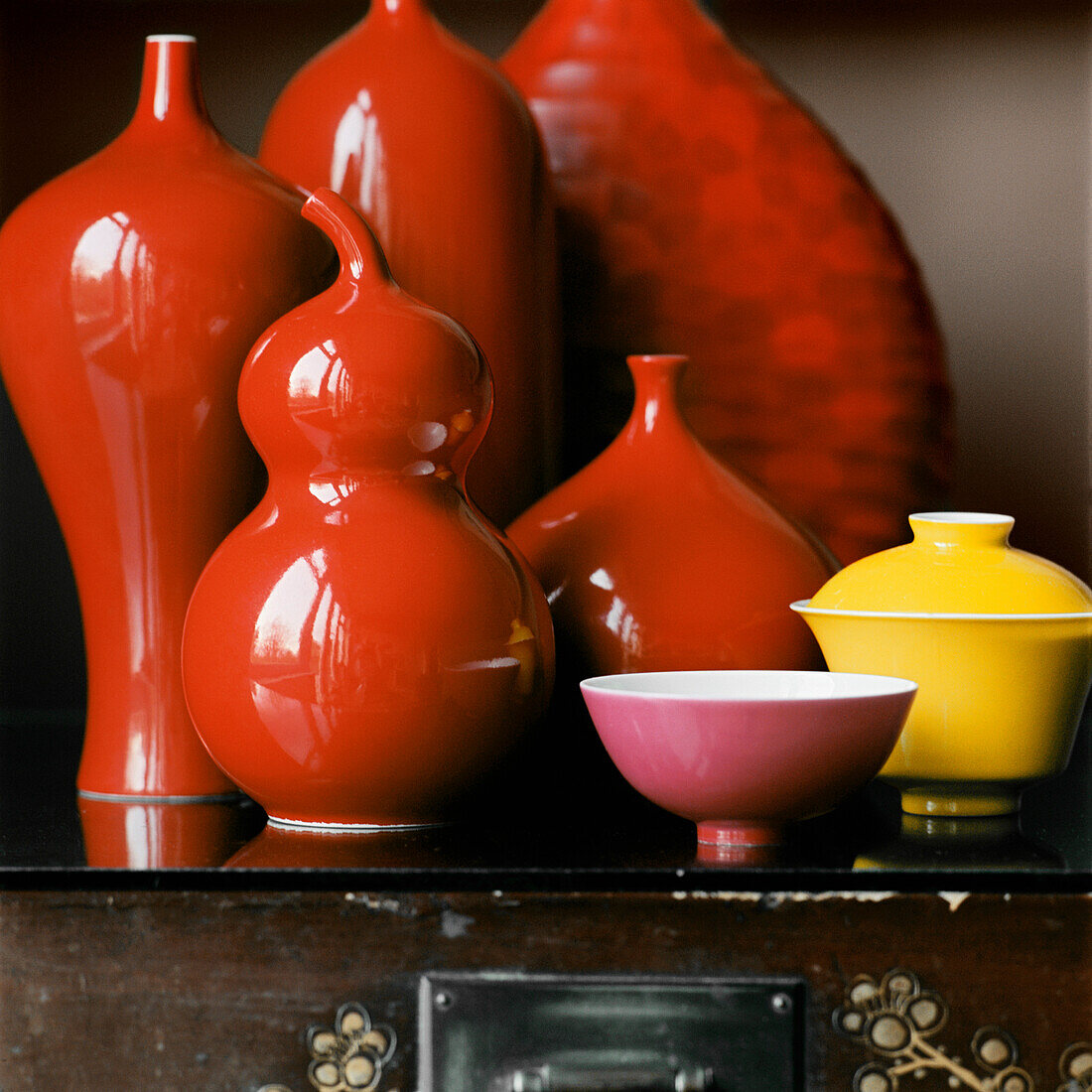 Display of red ceramic vases and vessels on a tabletop 