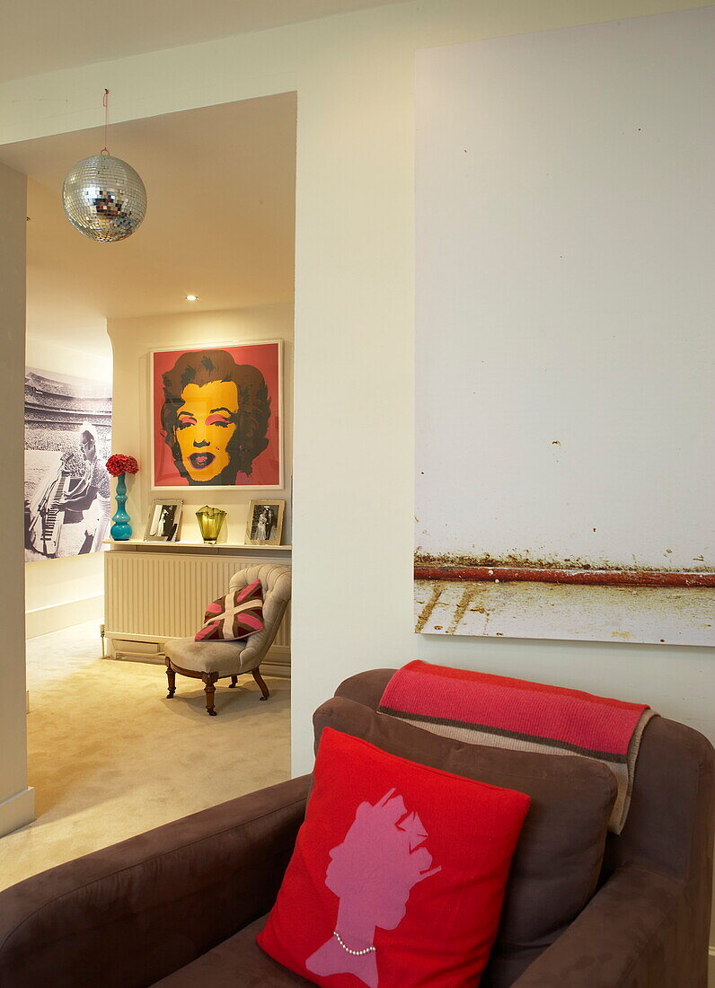 Disco ball with artworks and cushions in funky London home, England, UK