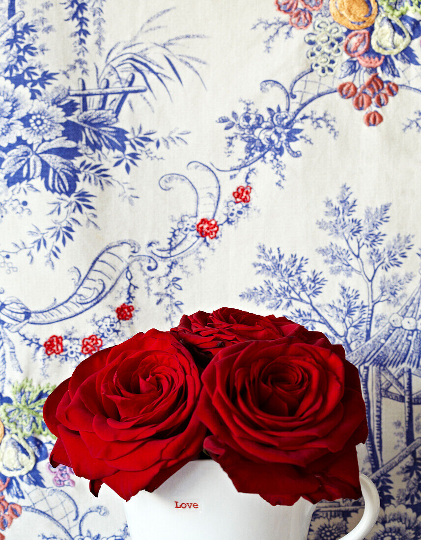 Red roses and blue floral wallpaper