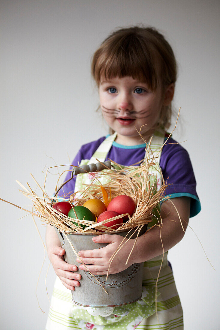 Young girl with bucket of multi-coloured Easter Eggs