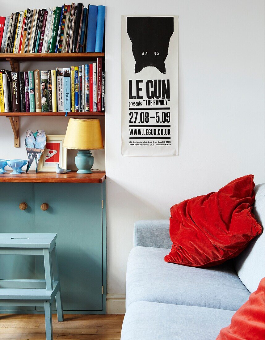 Red cushion on sofa in living room with bookcase