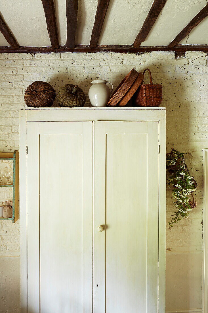 Cremeschrank mit Körben in einer Balkenküche in einem Haus in Cumbria, England, UK