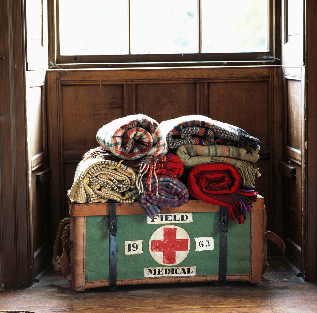 Rolled blankets on medical box in sunlit window of London home, UK