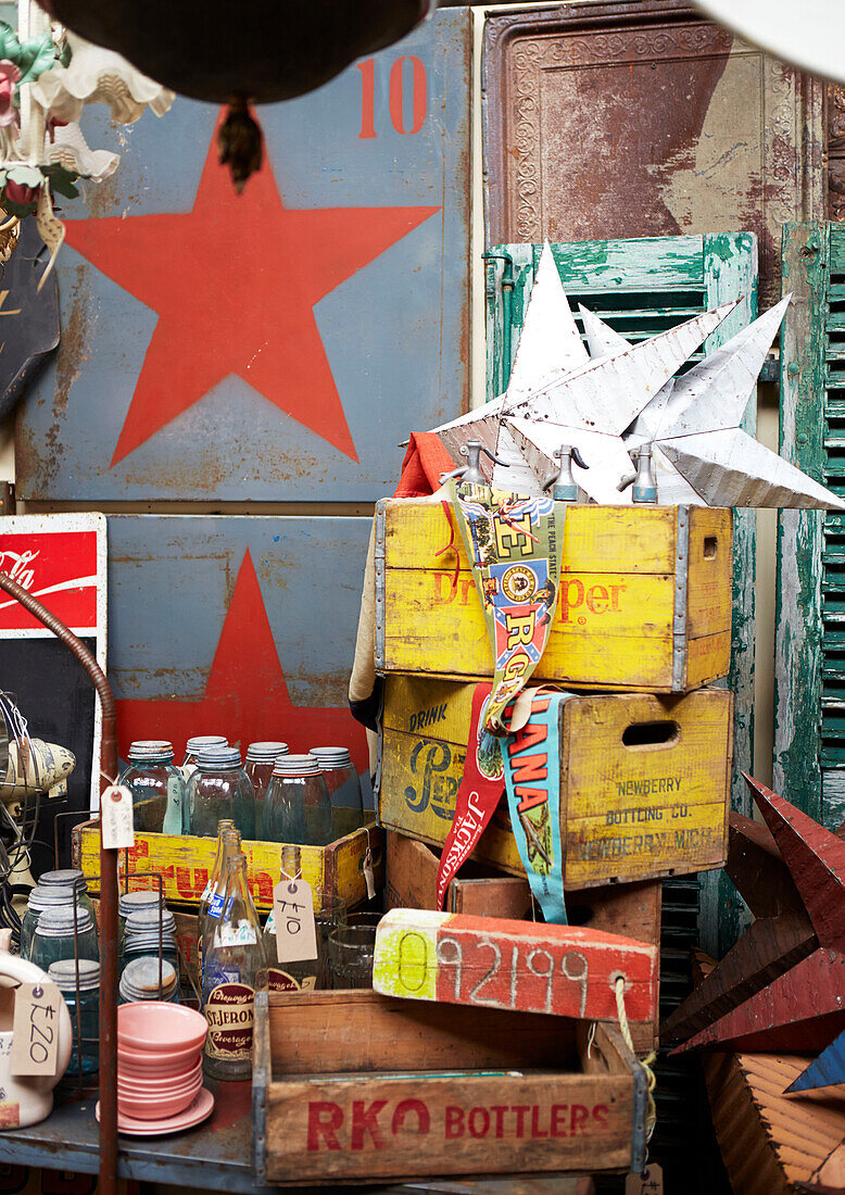 Collection of storage jars with stars and storage crates in Evershot antique shop, Dorset, kent, UK