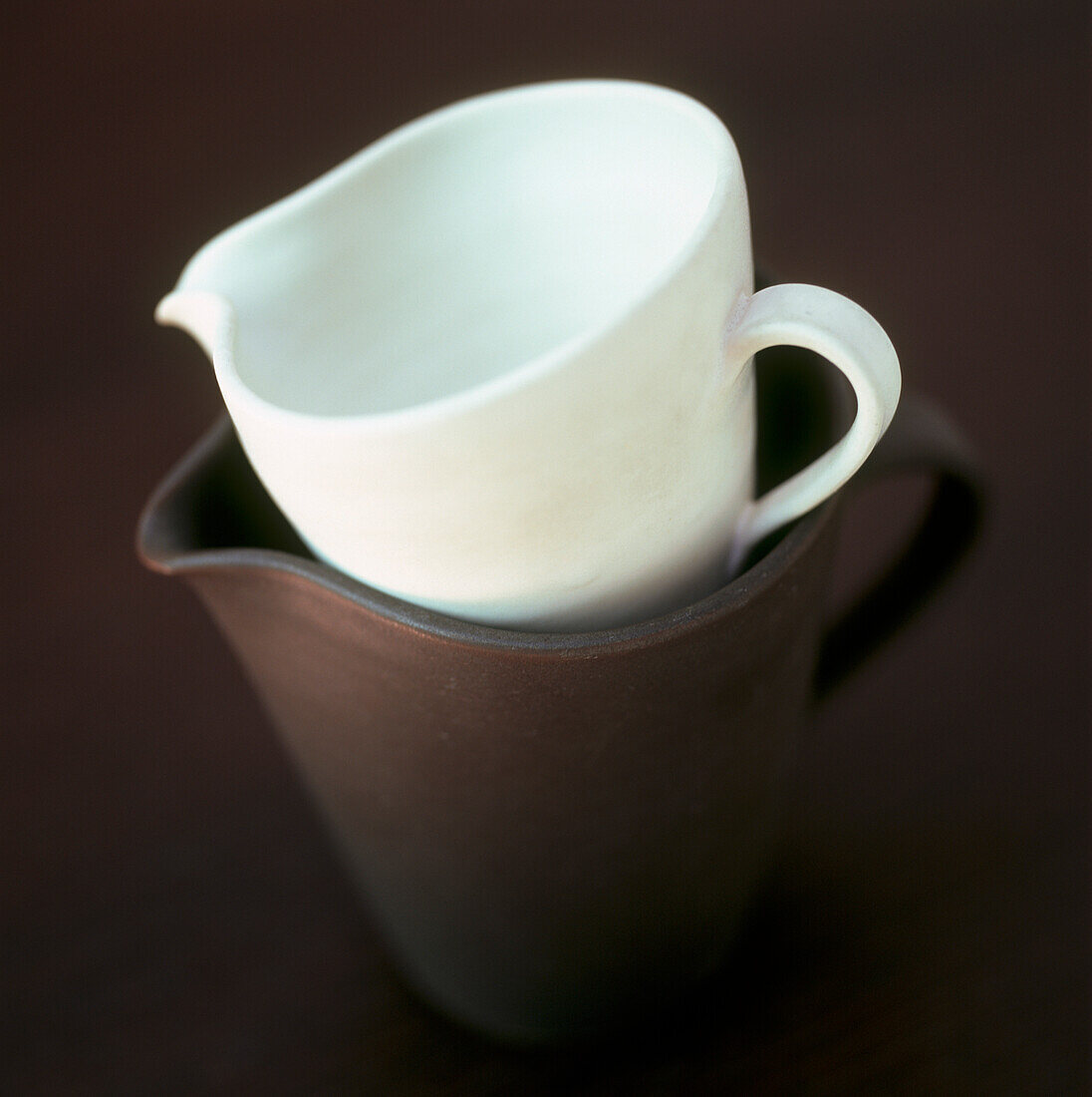 White and black porcelain jugs on dark background