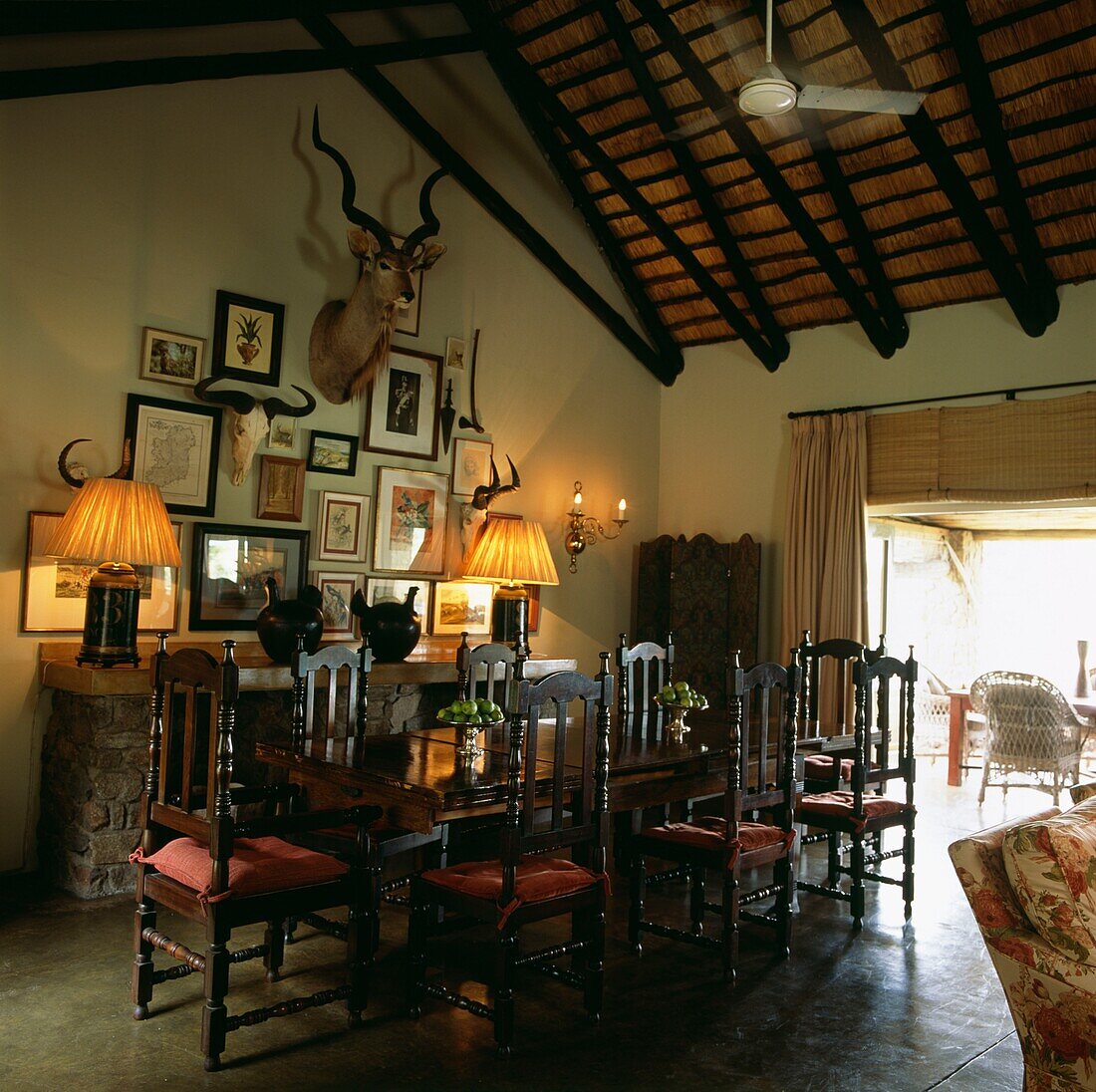 Matching lamps with artwork display in dining room with polished wooden table