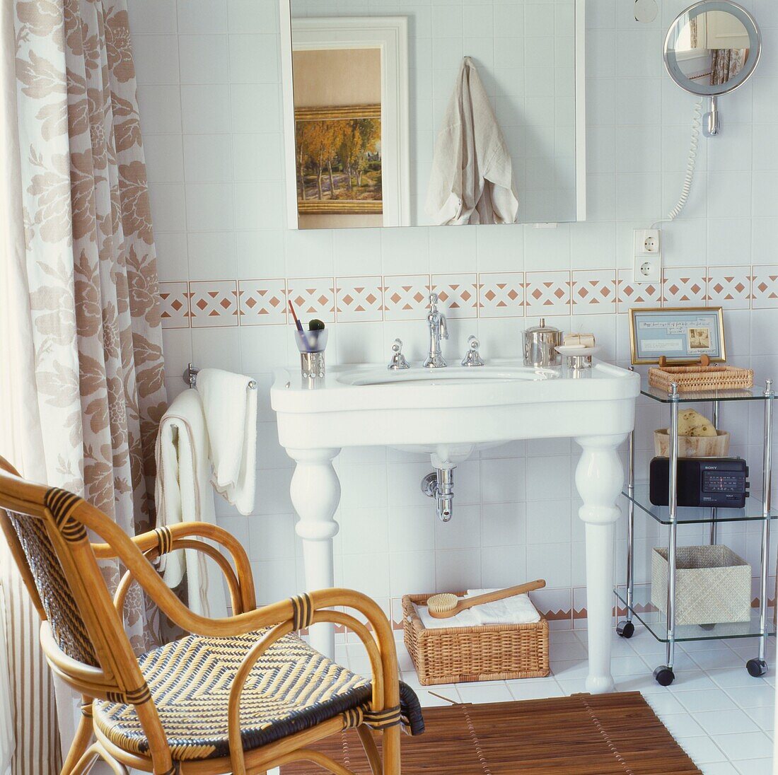 Cane armchair in bathroom with Victorian was basin and freestanding unit