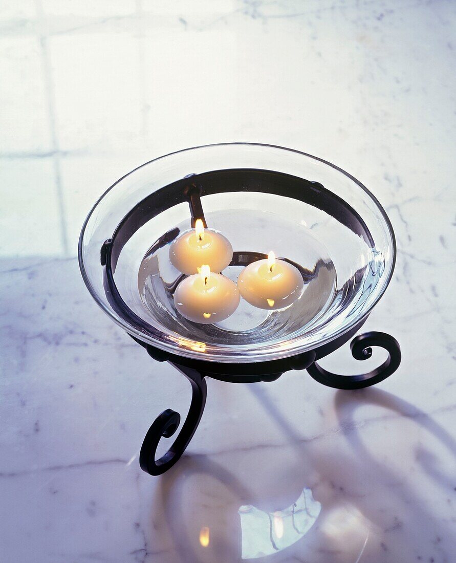 Floating candles in glass bowl on marble table top