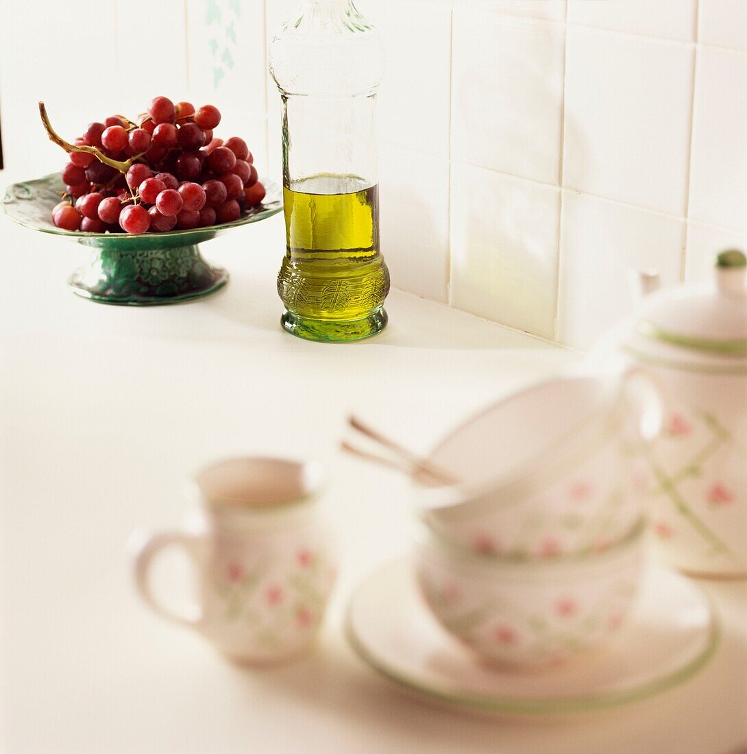 Teaset on worktop with bowl of cherries and cooking oil
