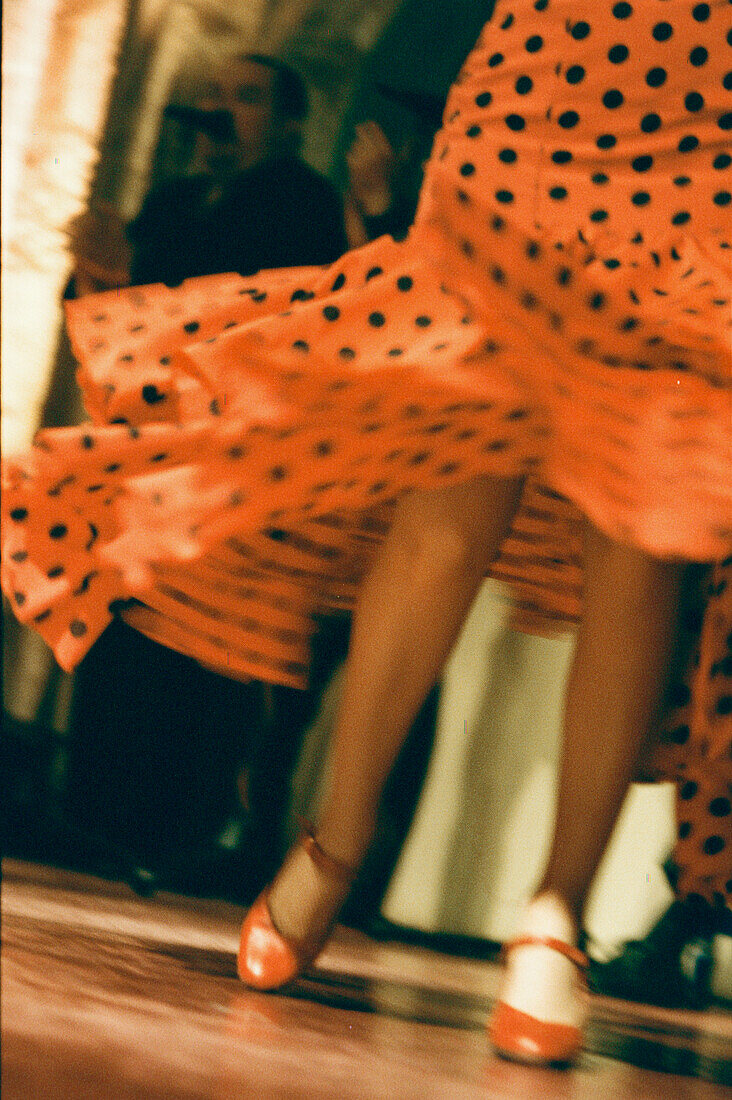 Flamenco-Tänzerin in einem rot gepunkteten Kleid bei einem Auftritt in einem Tablaos in Sevilla