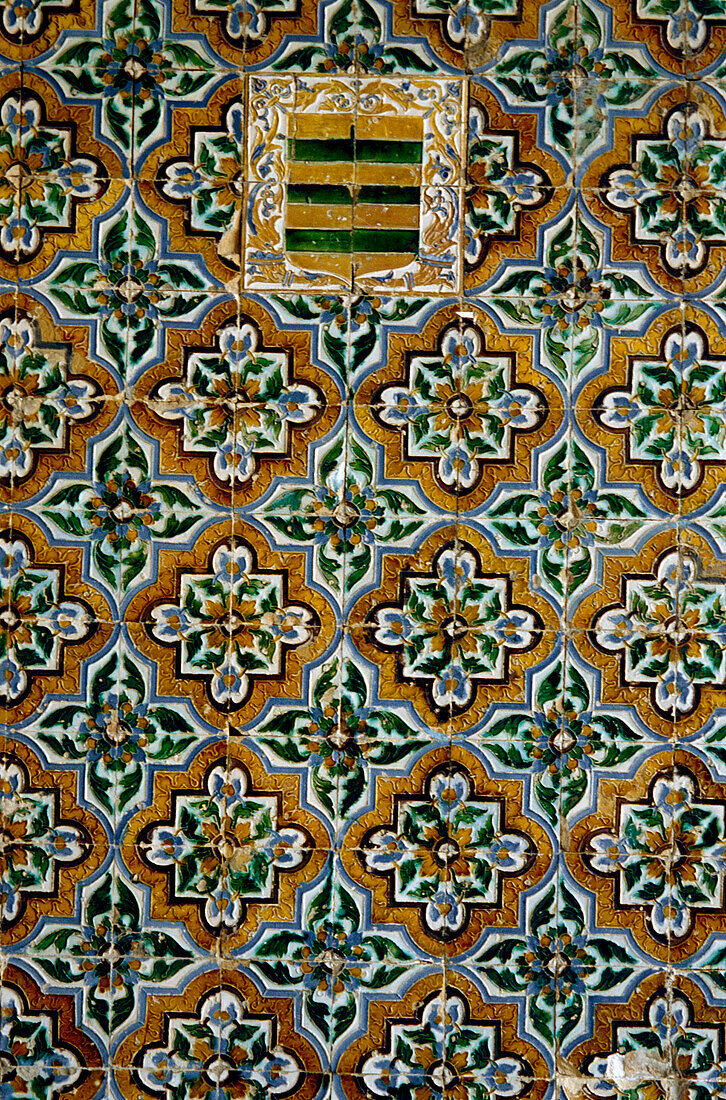 Azulejos tiles with coat of arms on a wall in the internal courtyard of the Casa Pilatos in the Santa Cruz area of Seville