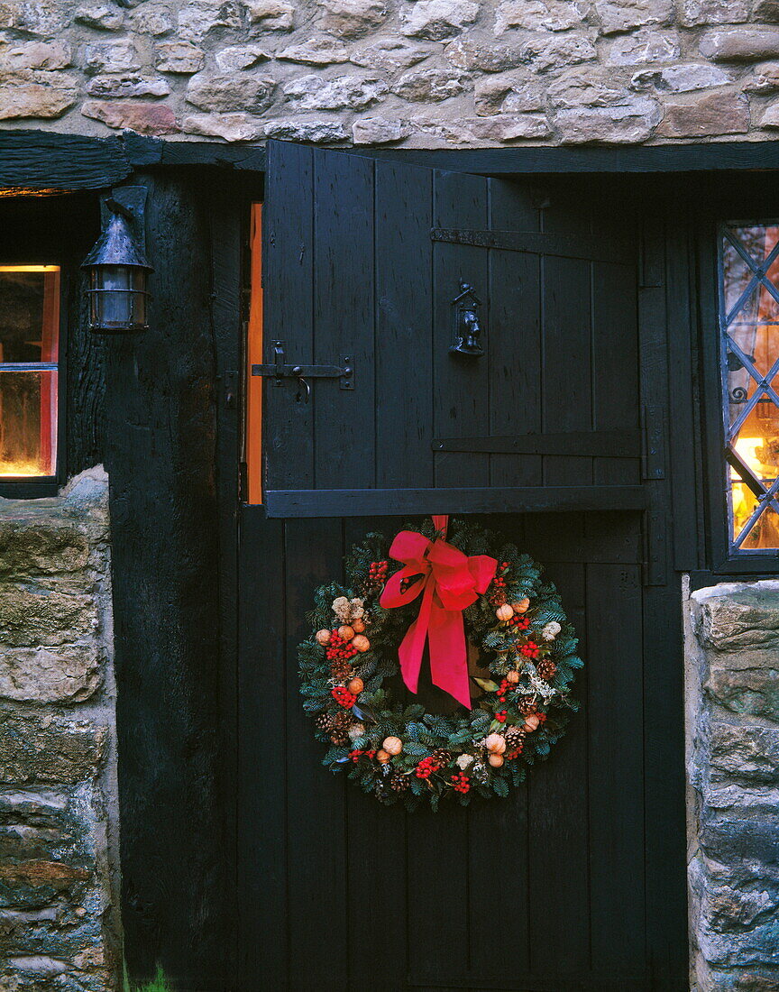 Weihnachtskranz an schwarzer Stalltür