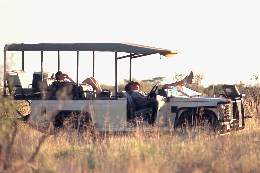 Field guides having a nap in one of the open-sided safari vehicles in the Tswalu Kalahari Game Reserve