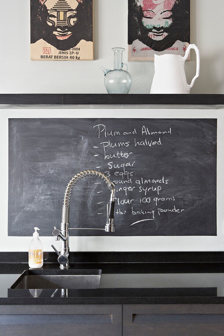 Shopping list on blackboard at sink with hose attachment in contemporary London home   UK