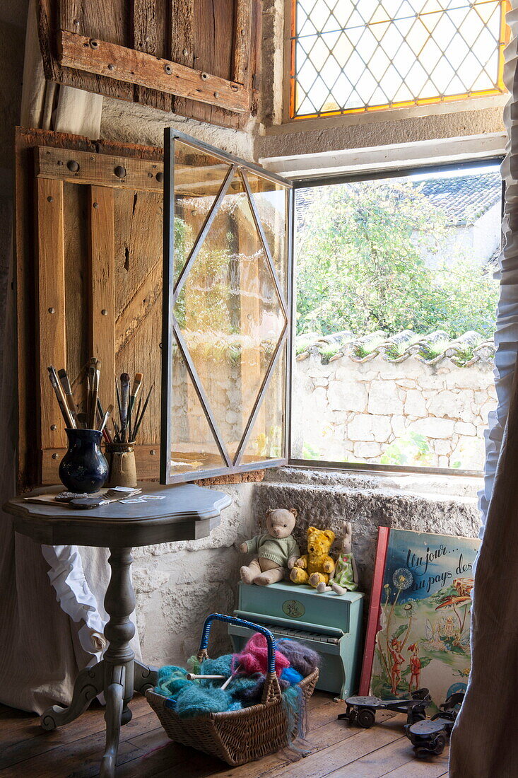 Pinsel auf Beistelltisch am offenen Fenster eines Bauernhauses in der Dordogne, Frankreich